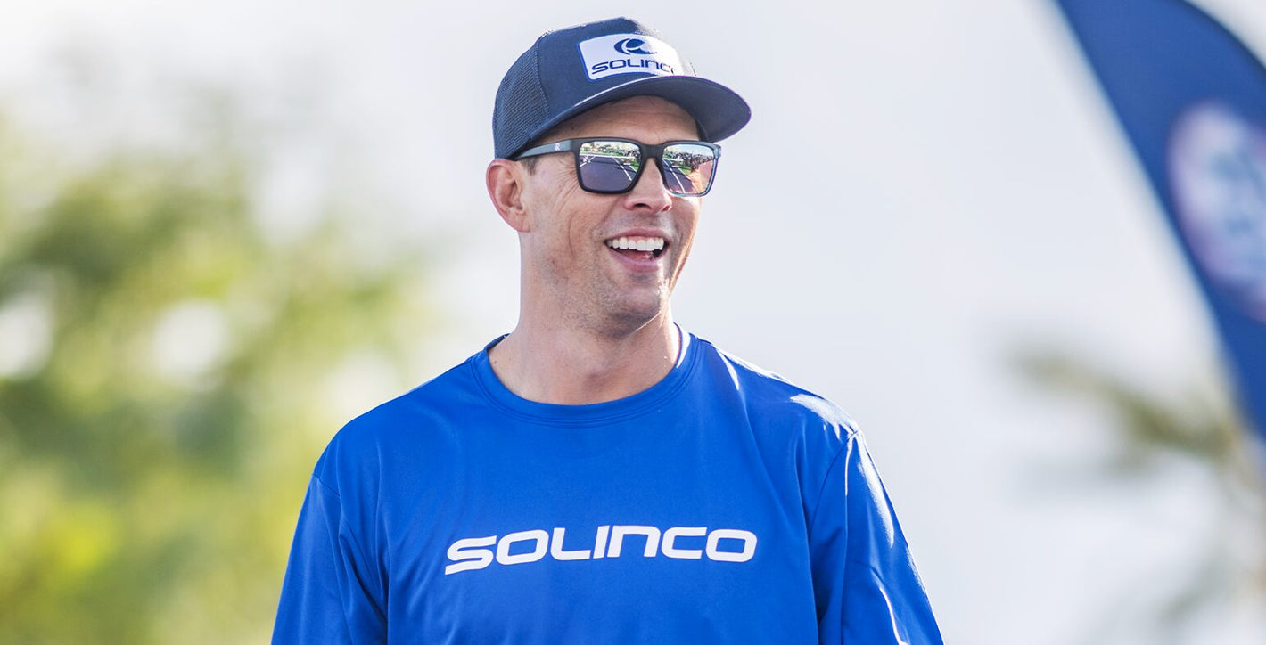 Mike Bryan em ação no court, com t-shirt e boné Solinco